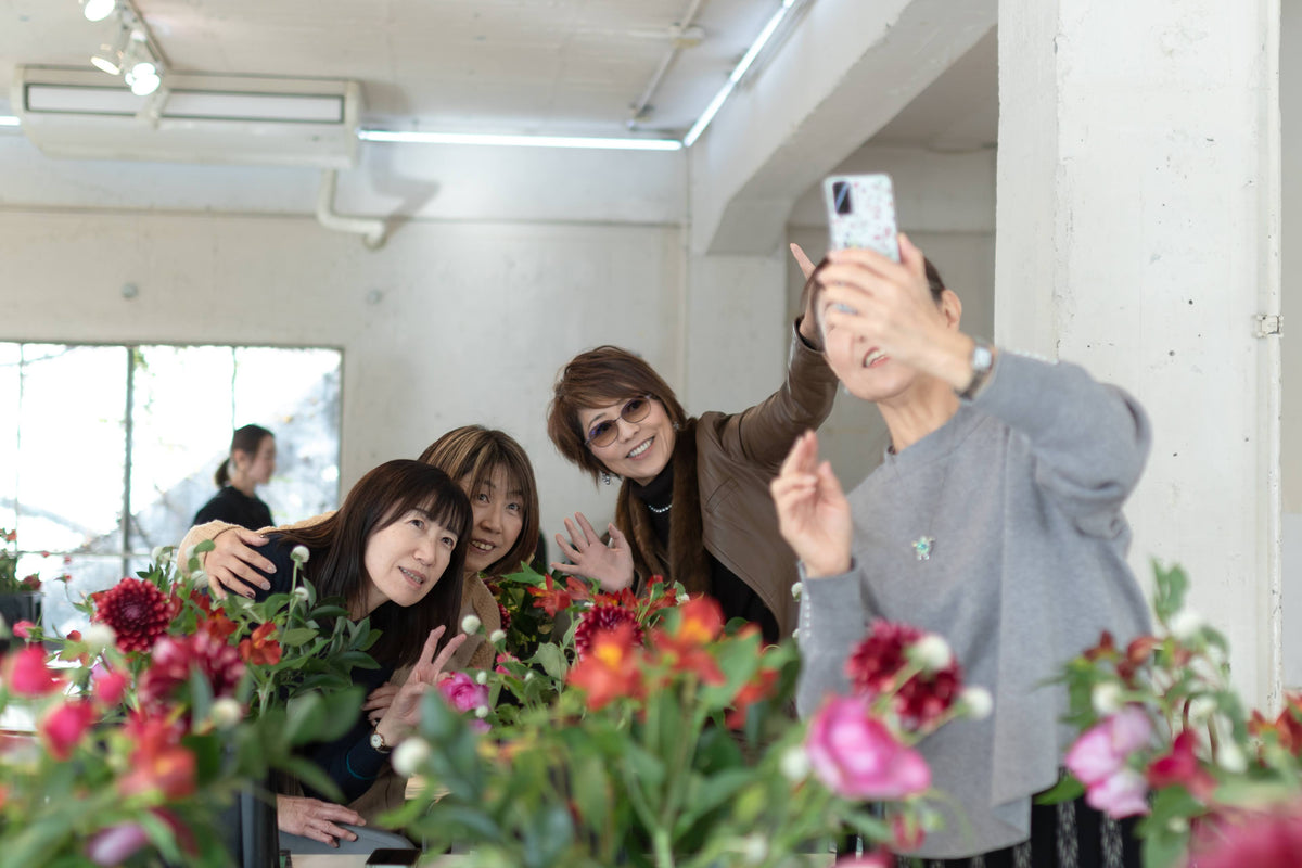 お花を囲むtomosuの会で、写真を撮り合う参加者